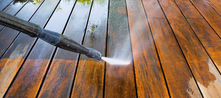 Pressure washer wand cleaning a wood surface