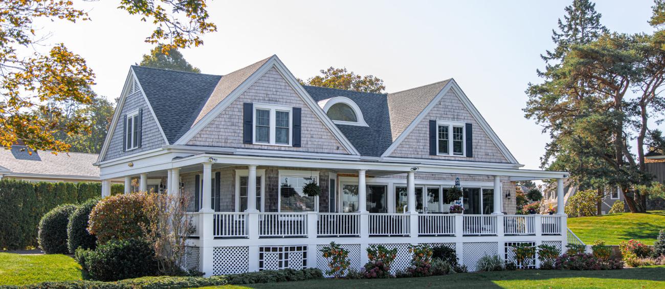 White two-story home with a wraparound porch