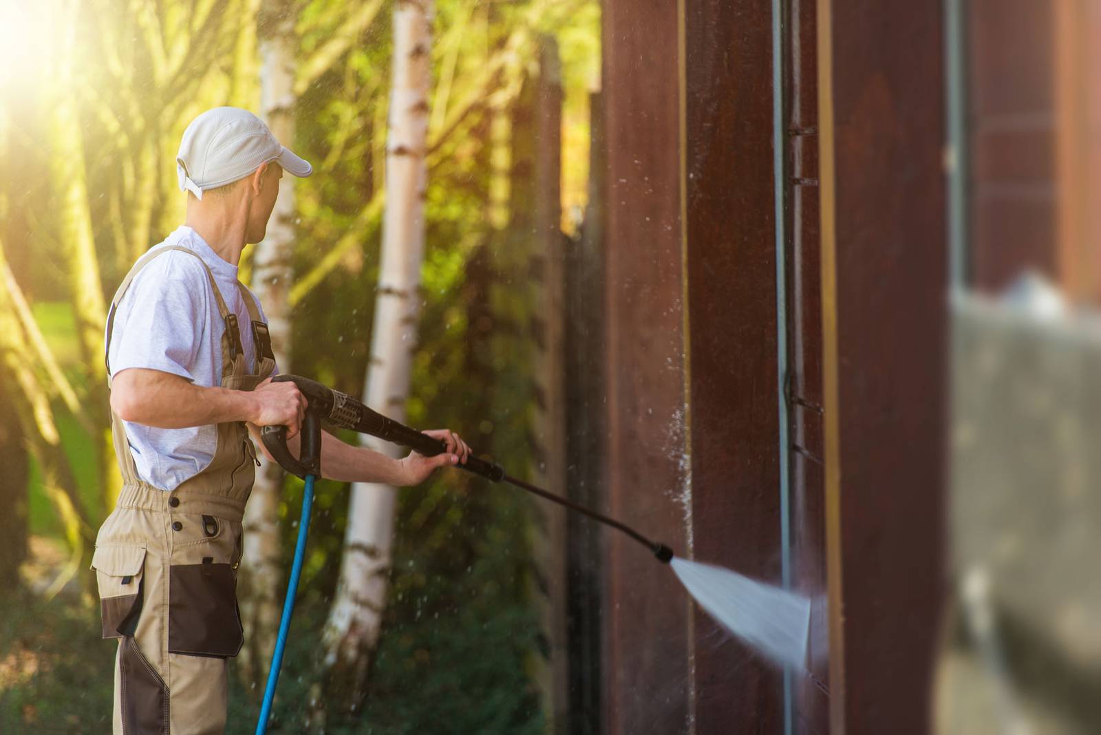 Technician pressure washing an exterior surface